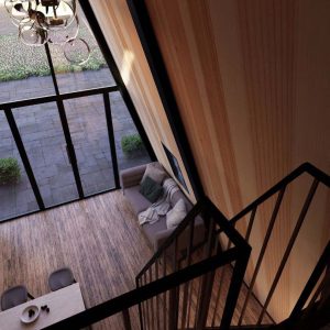 Unutrašnji prostor A-Frame kućice sa drvenim zidovima, panoramskim staklenim prozorima, udobnim dnevnim boravkom i minimalističkim stepenicama koje vode na galeriju.